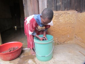 Anita washes clothing in order to help her grandmother.  Today, she is washing her school uniform in preparation for her return to school. 