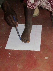 Mr Mugo is tracing my foot so I can get shoes.  It is a very exciting day for me!