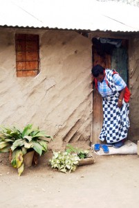 My mom standing outside of our mud home in Arusha, Tanzania in 2009.