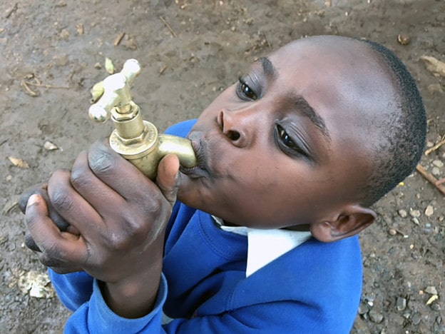 BOY DRINKING FROM FAUCET - RAILA PRIMARY - 500 DPI